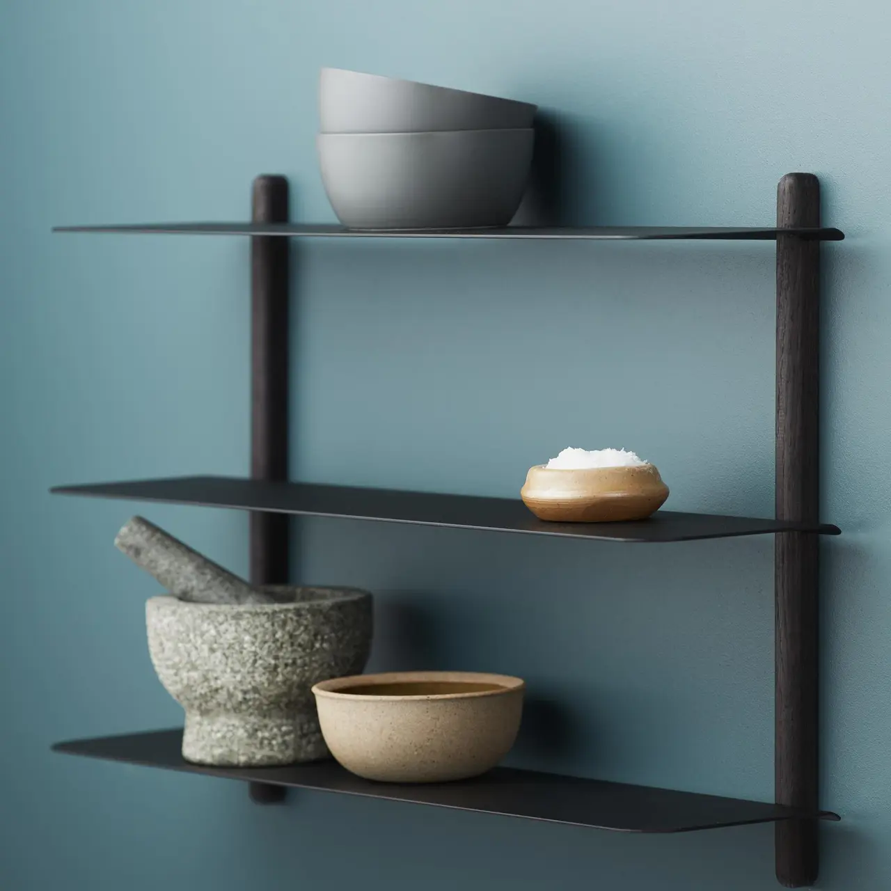 Hand holding black machined steel mechanical pencil with brass tip and top.